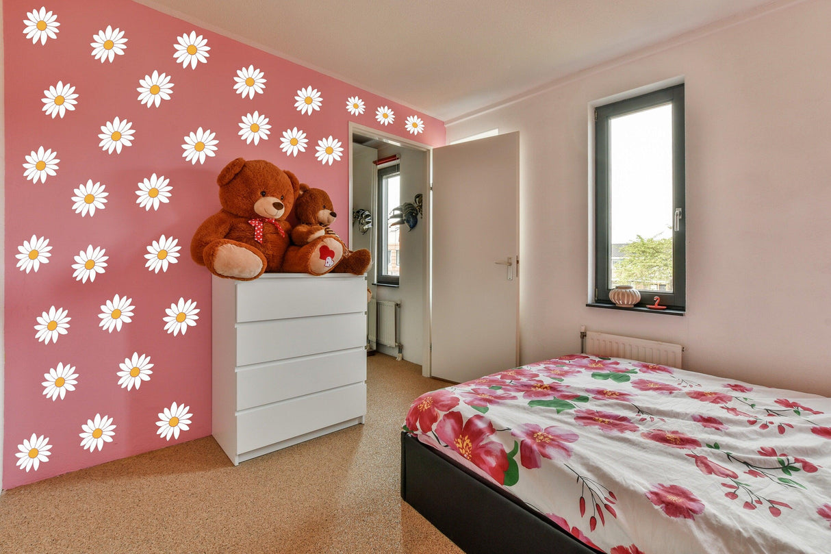 Bright bedroom featuring 24 white daisy wall decals on pink wall, with a flower-patterned bed and teddy bears.