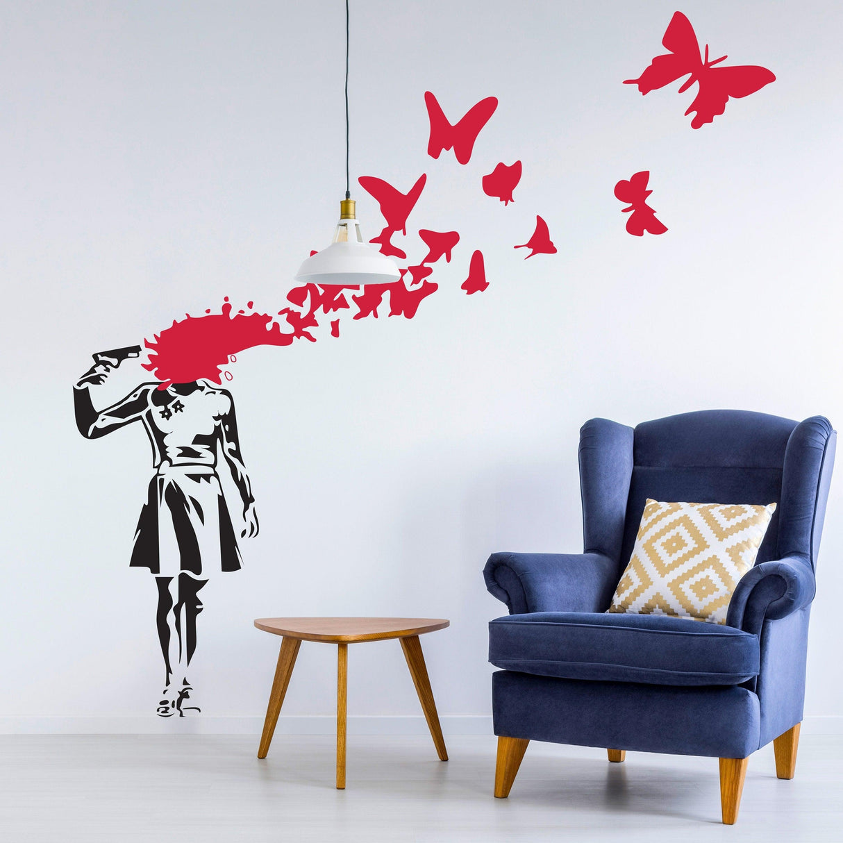 Banksy-style wall decal of a girl with a gun, colorful butterflies emerging, stylish room decor.
