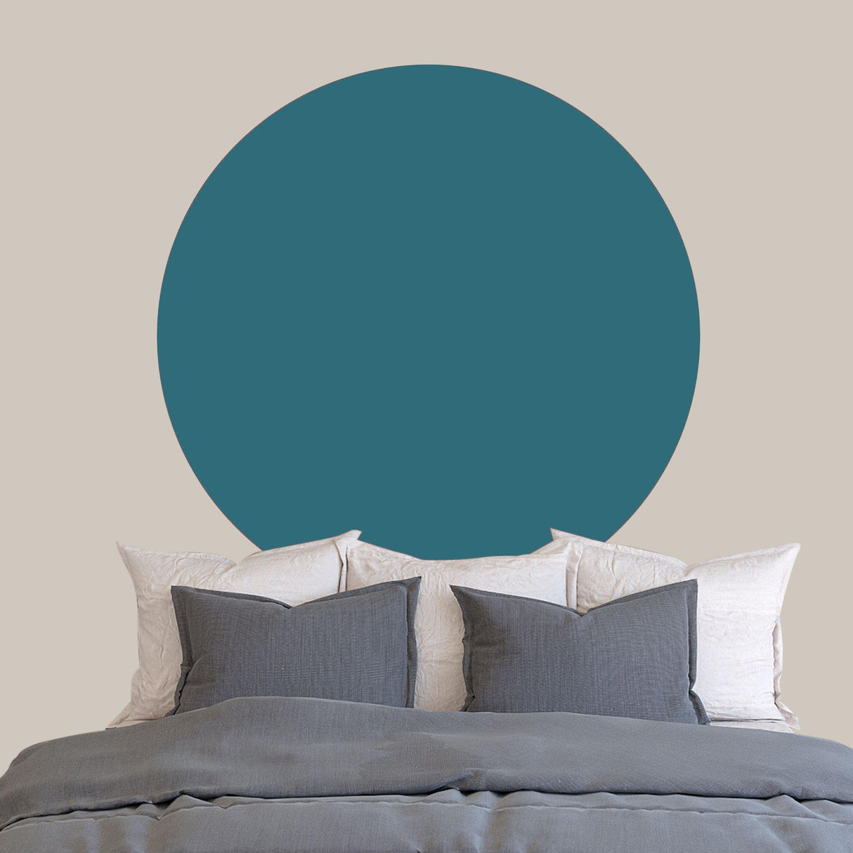 Scandinavian style circle wall sticker in teal above a cozy bed with gray pillows, enhancing interior decor.