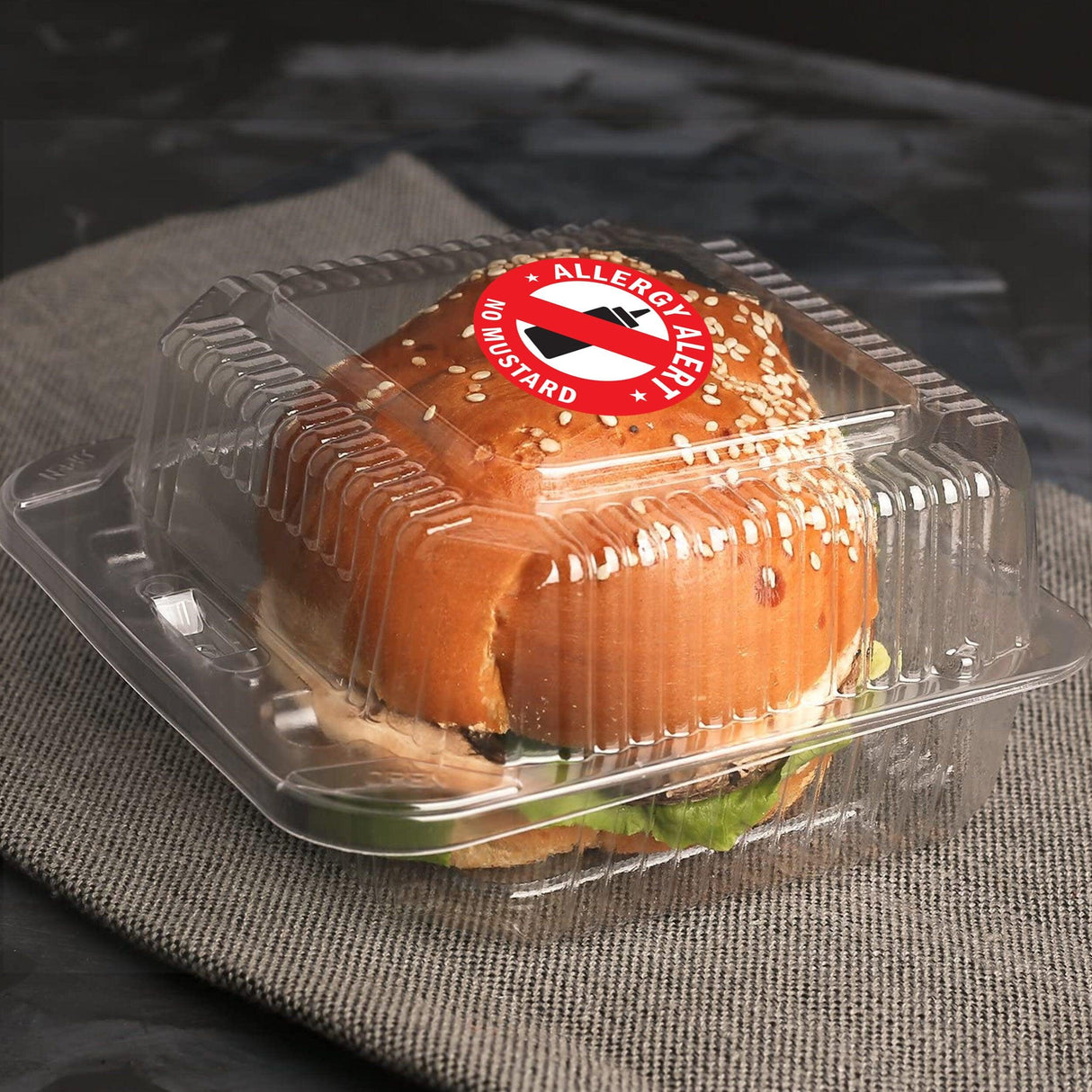 A packed sandwich with a mustard allergy alert sticker on clear container, ensuring food safety.