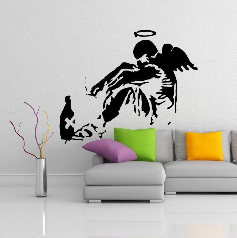 Banksy Fallen Angel wall sticker design featuring angel with wings and halo on minimalist wall.