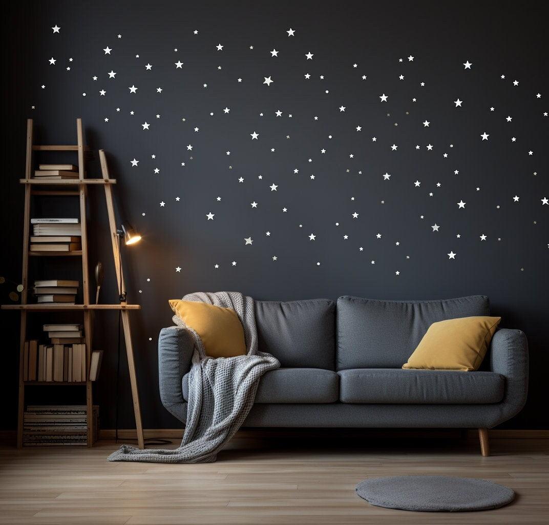 White stars wall vinyl stickers on dark wall above cozy gray couch with yellow pillows and ladder bookshelf.