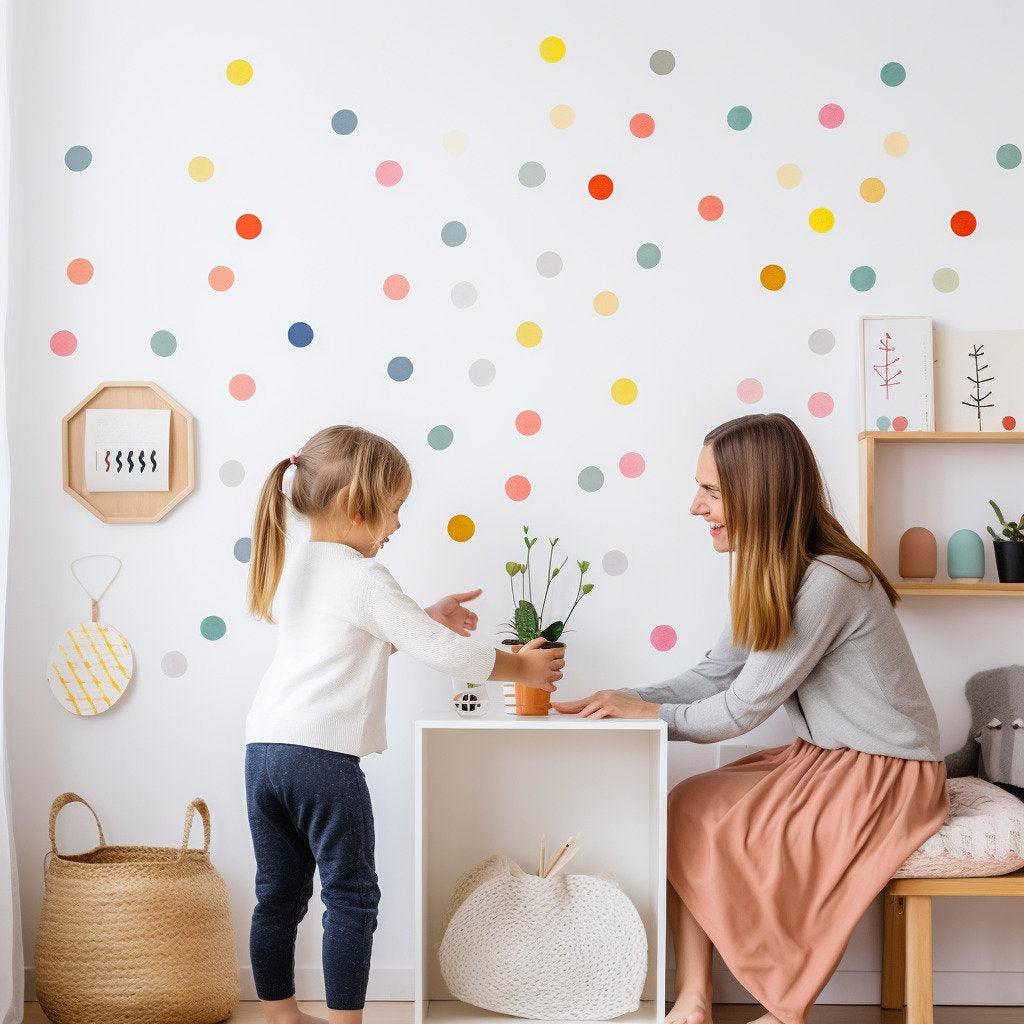 A mother and daughter enjoying playtime in a colorful room decorated with vibrant watercolor dot decals.