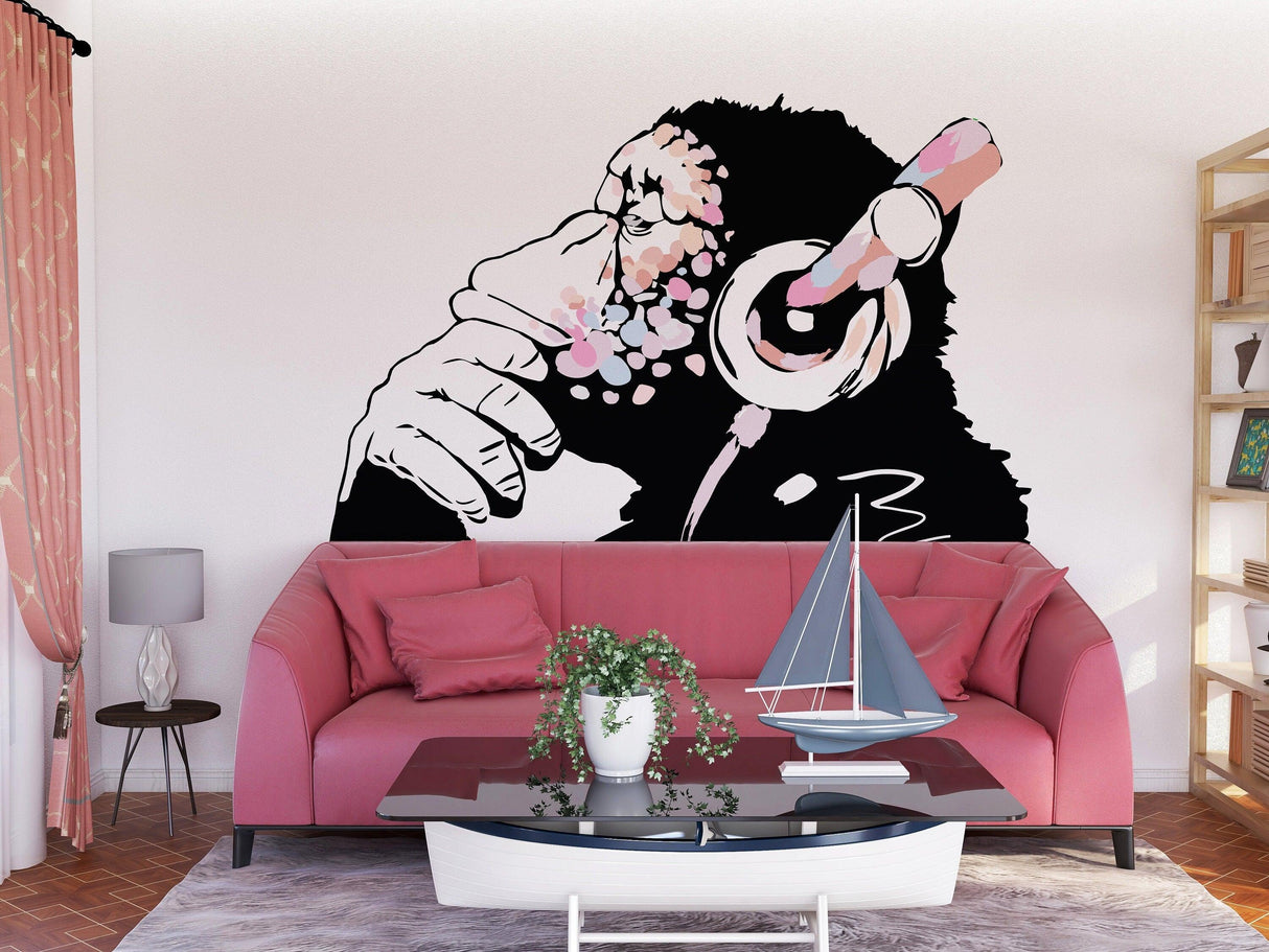Banksy-inspired monkey decal in pink, stylish wall art for boho girls' rooms, featuring a thoughtful chimp with headphones.