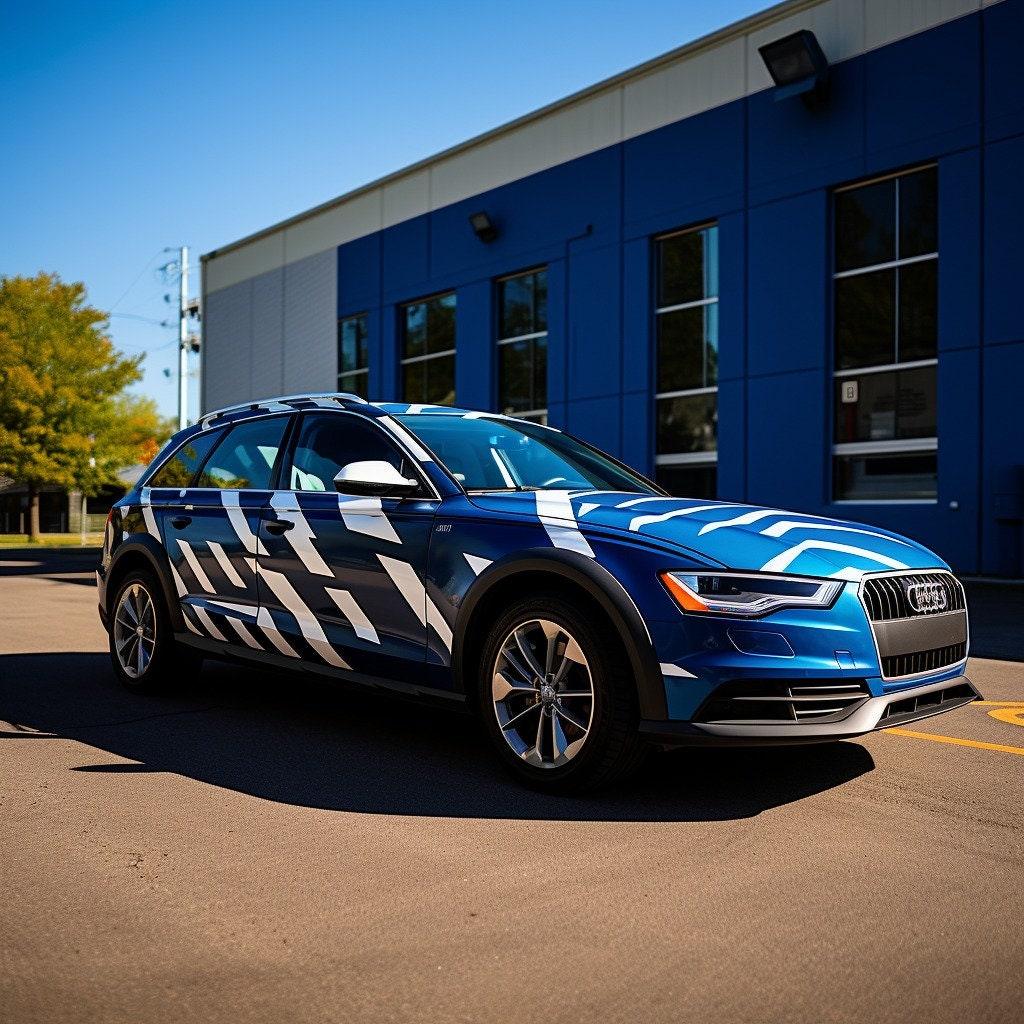 Blue car adorned with stylish white geometric vinyl decals parked in front of a modern building.
