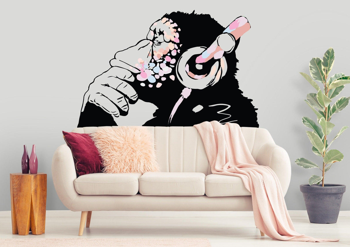 Banksy-inspired thinking monkey decal in pink, showcasing a headphone-wearing chimp in a stylish boho living room.