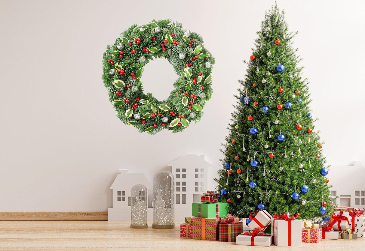 Verdant Christmas wreath wall decal with green leaves and red berries above a decorated Christmas tree and gifts.