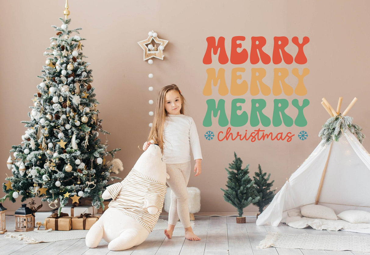 Festive Christmas wall sticker with colorful 'Merry Merry Merry Christmas' text next to a girl and decorated tree.