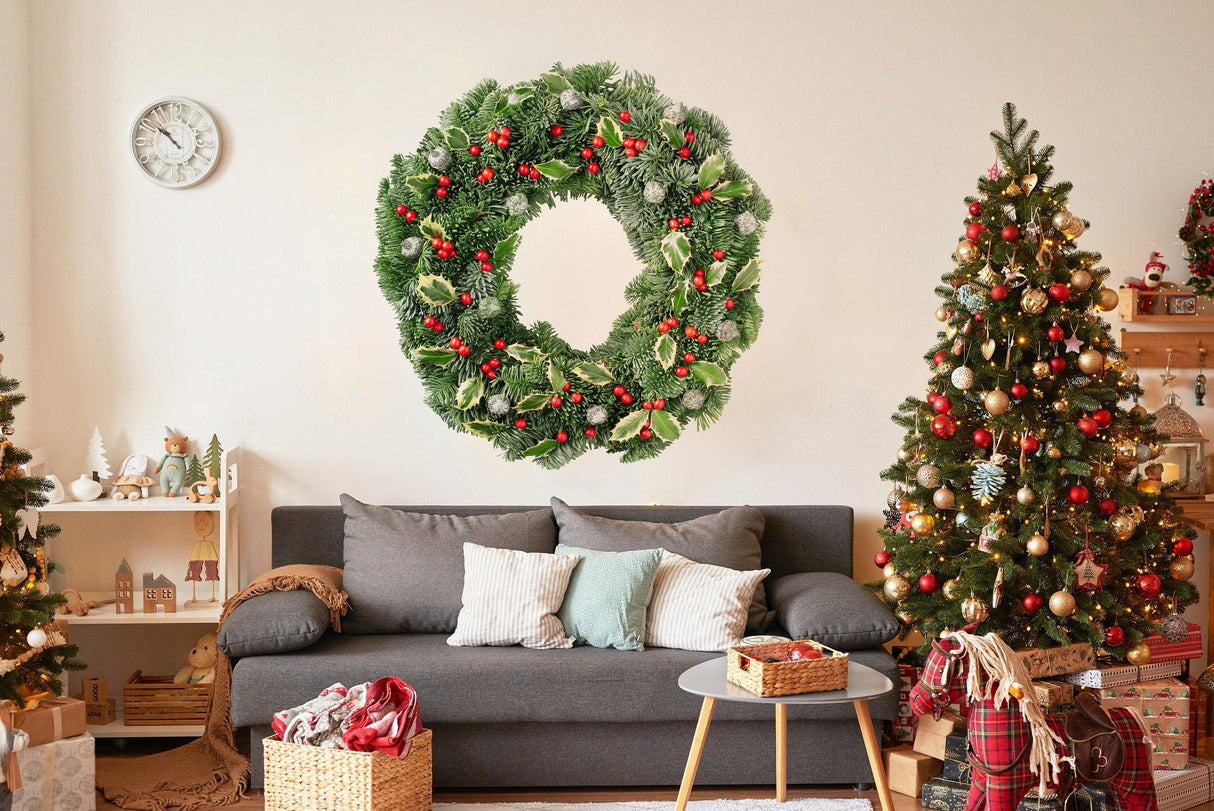 Lush green Christmas wreath wall decal with red berries, enhancing festive home decor in cozy living room.