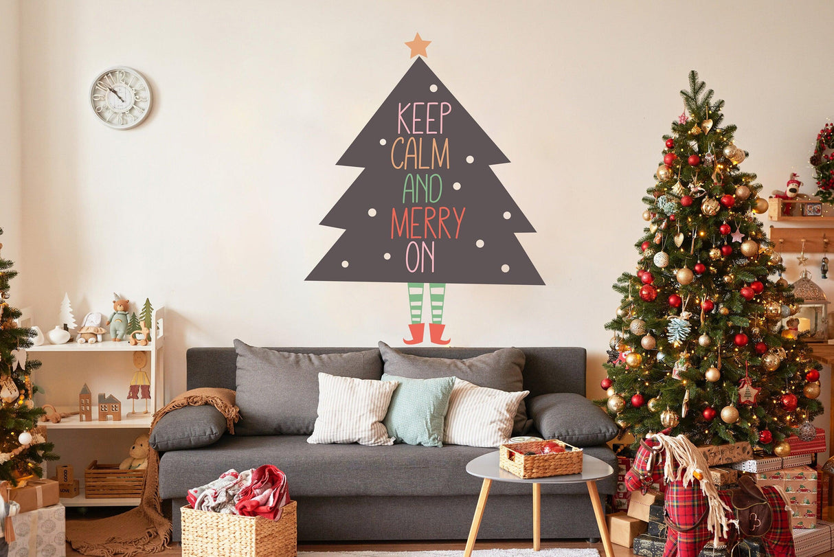 Whimsical Christmas tree with legs wall sticker in a cozy living room, featuring 'Keep Calm and Merry On' text.
