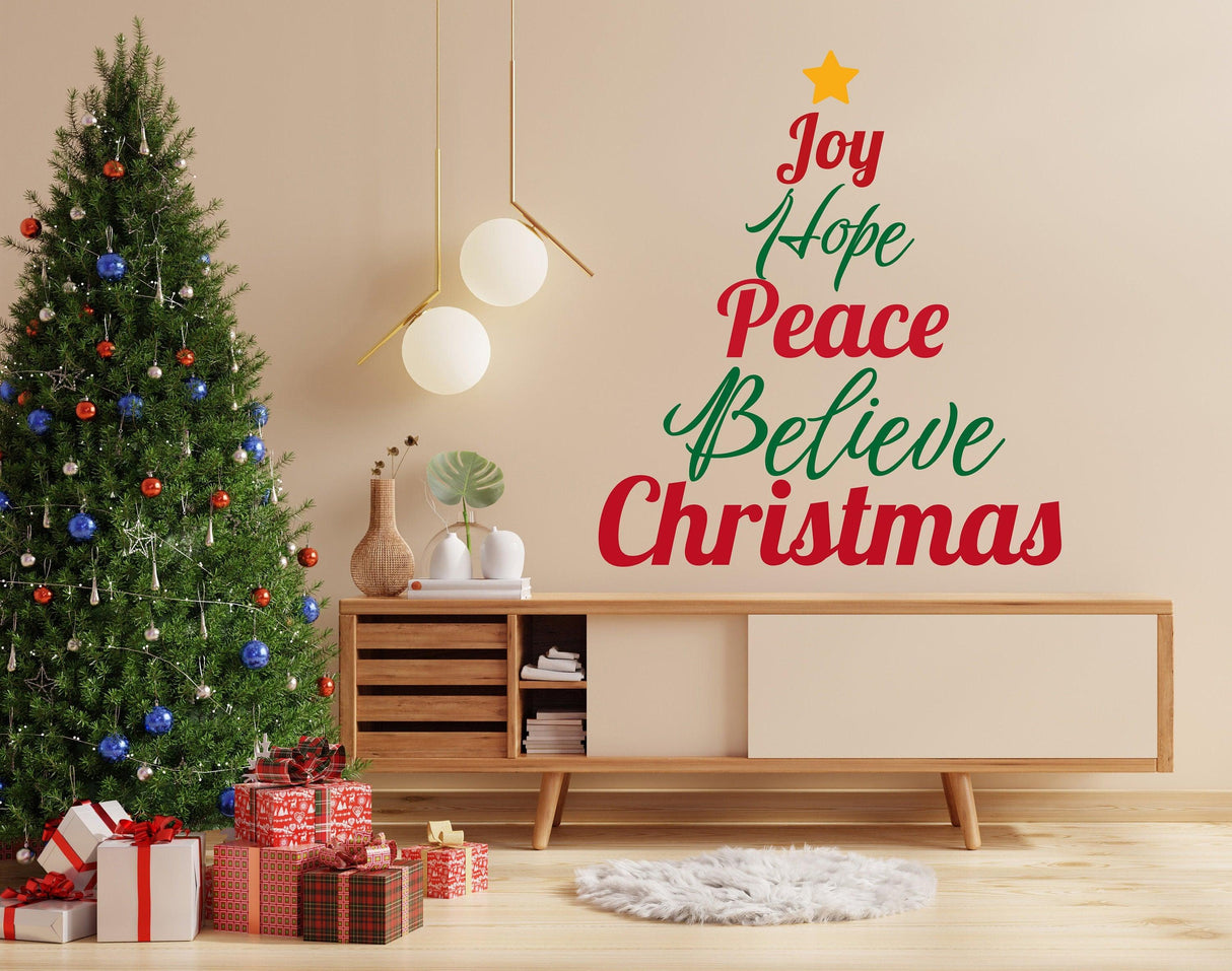 Christmas quote wall decal with 'Joy Hope Peace Believe Christmas' on a living room wall by a festive tree.