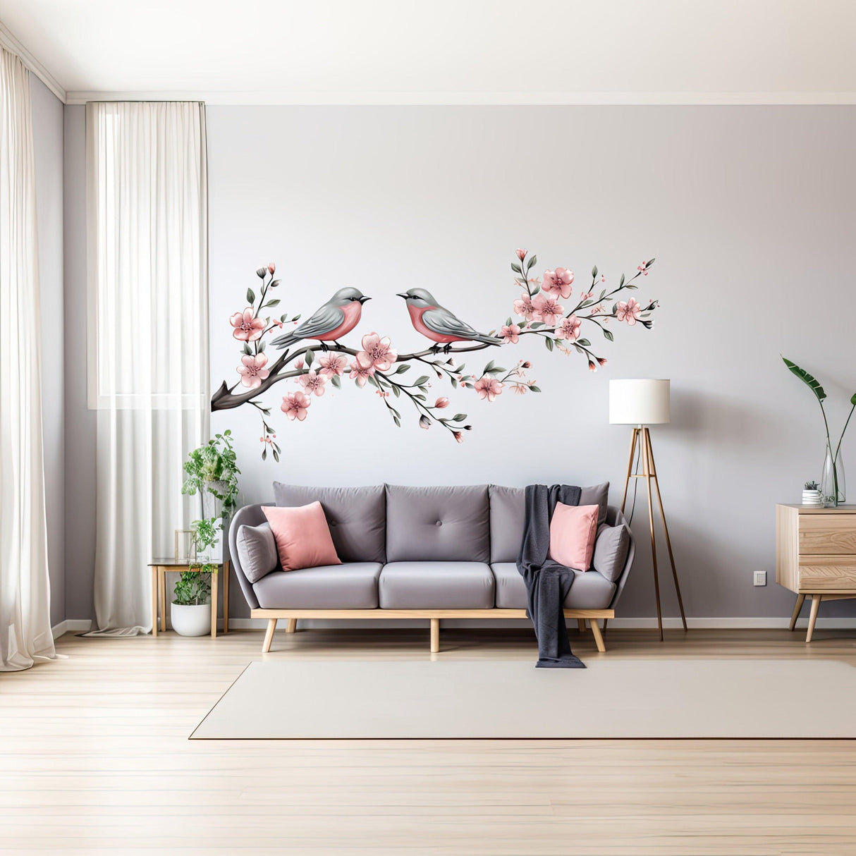 Elegant tree branch wall decal with birds and pink flowers in a stylish living room.