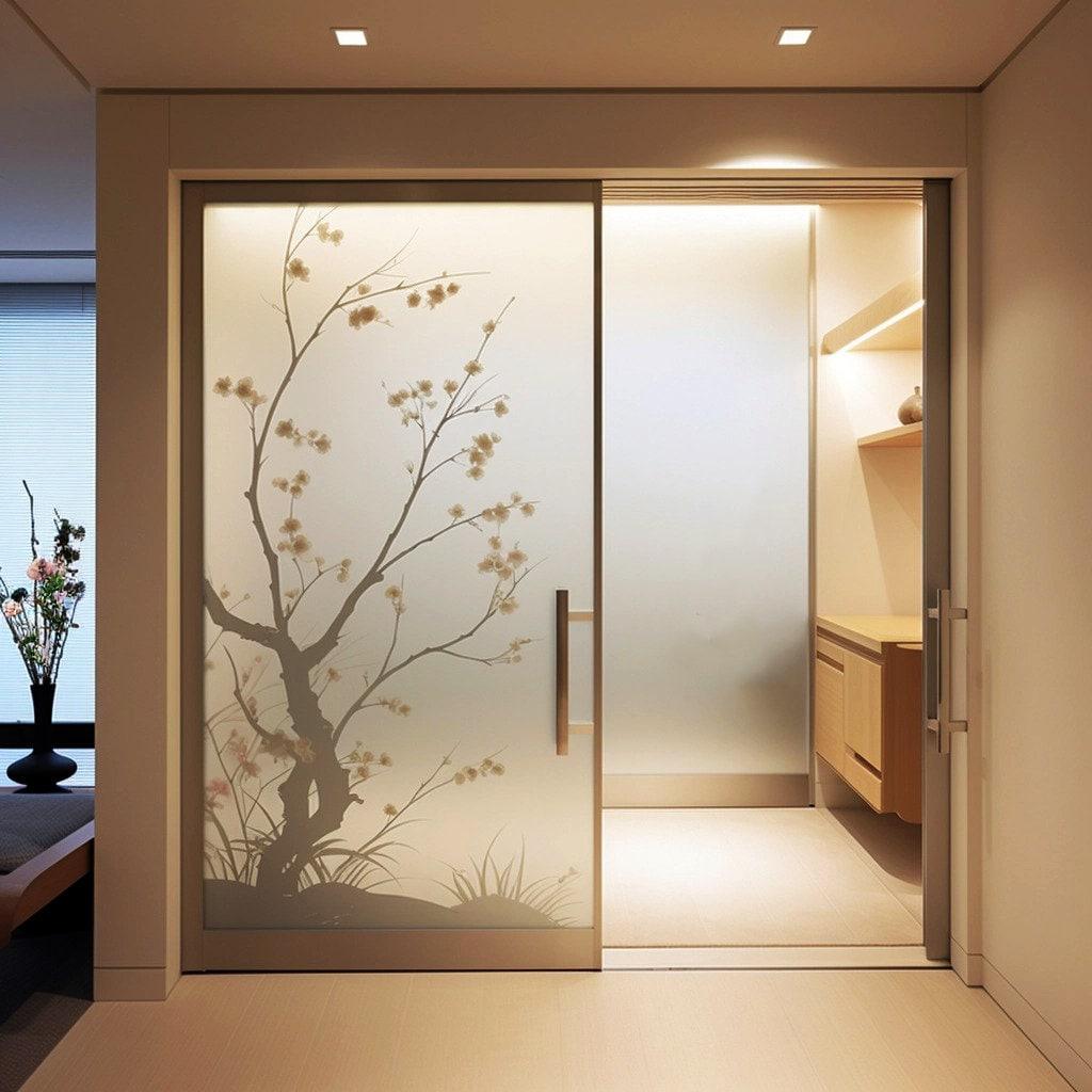 Frosted black cherry blossom tree silhouette decal on a glass door, adding elegance and privacy to modern interiors.