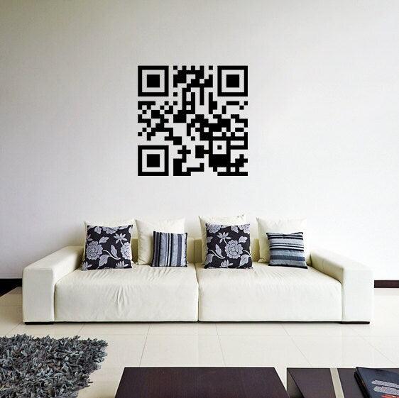 Stylish living room featuring a personalized QR code sticker on the wall above a modern white sofa with decorative pillows.