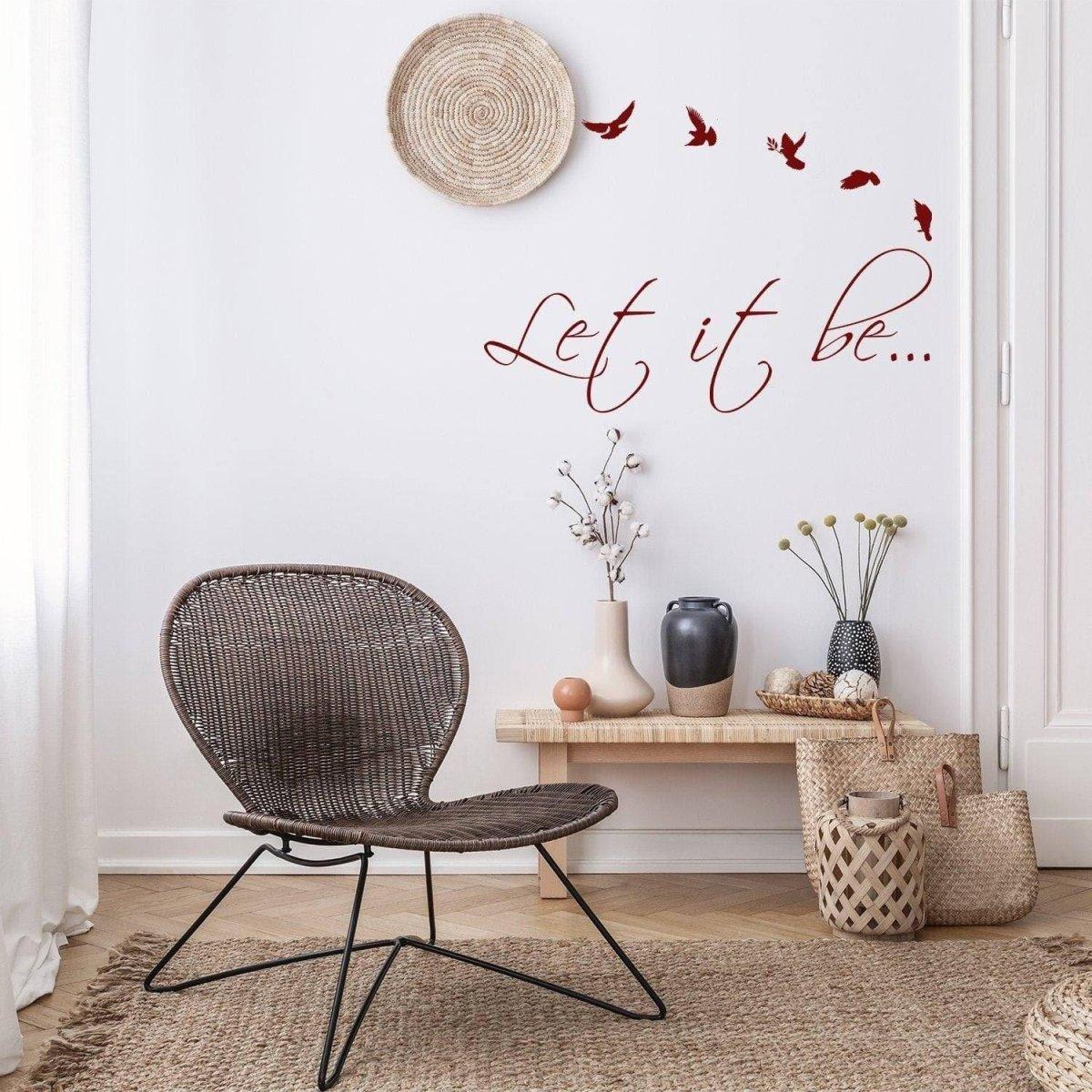 Motivational wall sticker "Let it be" with flying birds in a cozy interior setting.