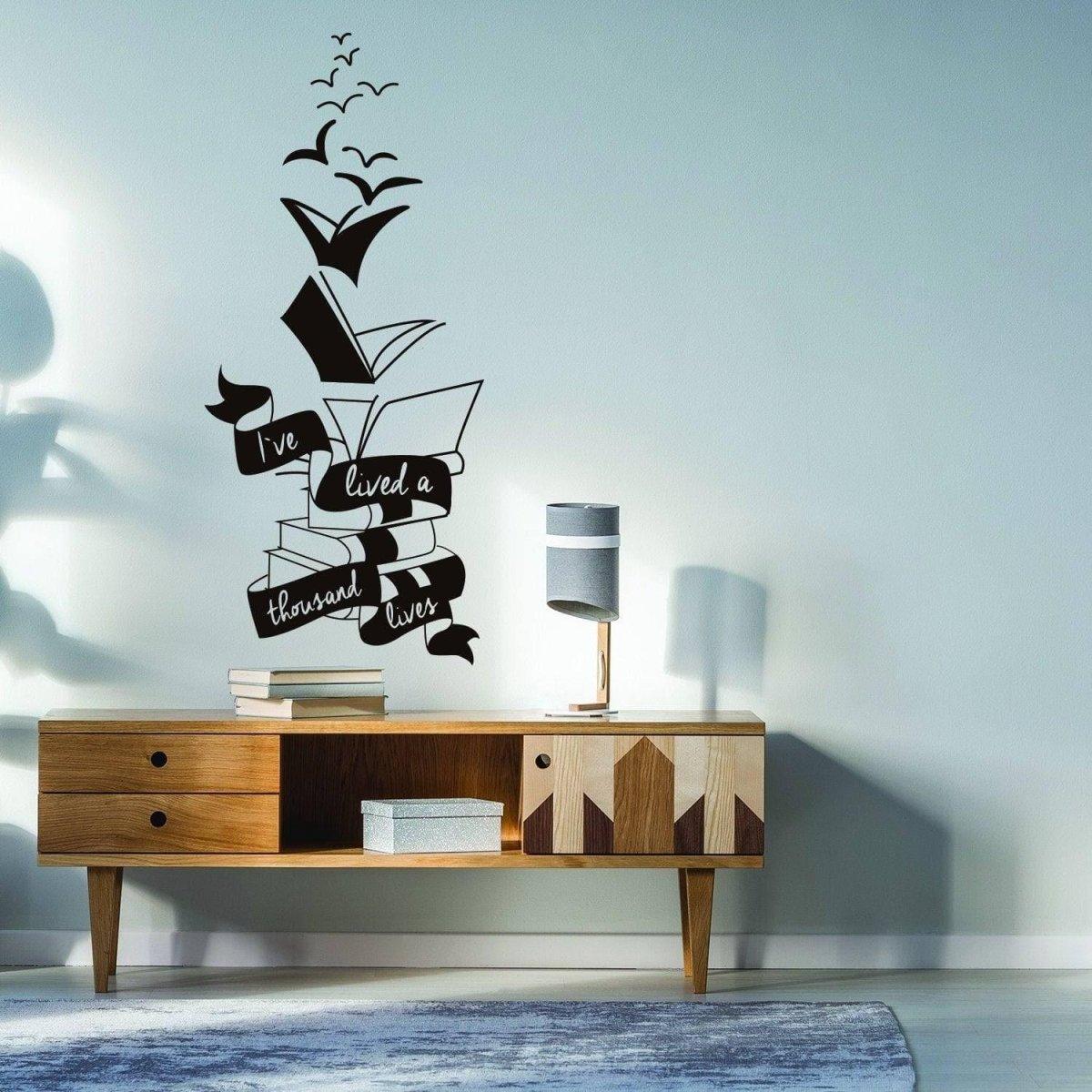 Motivational wall sticker design featuring books and birds with the phrase 'I've lived a thousand lives' in a stylish living room.