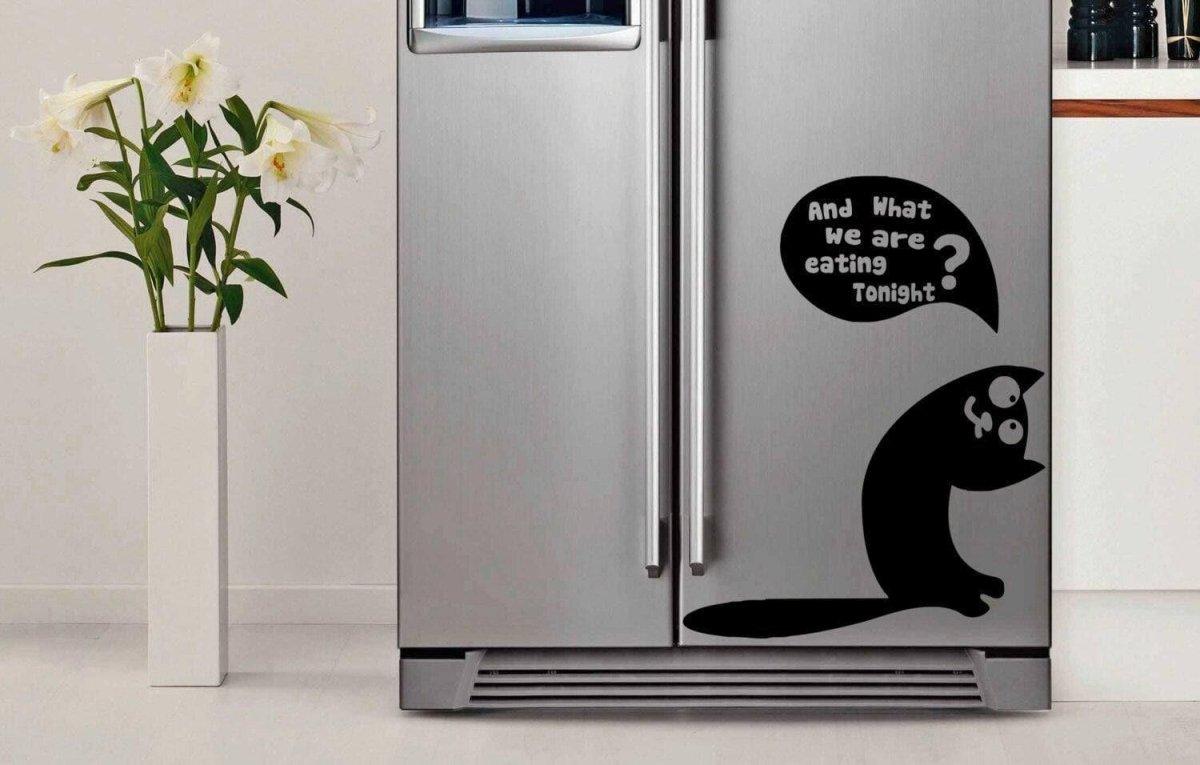 Whimsical die cut vinyl sticker of a cat on a kitchen fridge with text asking, 'And what are we eating tonight?'
