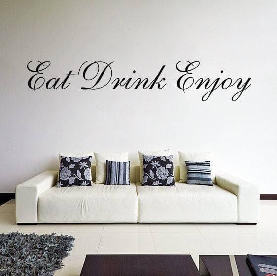 Elegant vinyl wall decal reading 'Eat Drink Enjoy' displayed above a modern couch with decorative pillows.