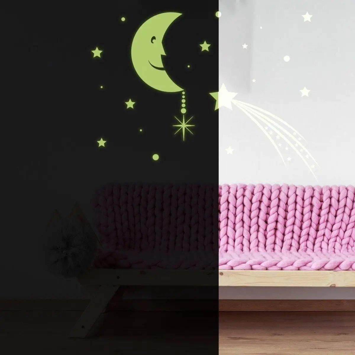 Glowing moon and stars wall decals in a cozy room with pink sofa, ideal for a magical kids' bedroom decor.