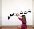 Santa sleigh and reindeer wall decal shown in an alternate seasonal interior view.
