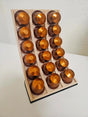 Modern 3D printed coffee capsule organizer displaying orange aluminium espresso capsules.
