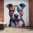 Large, colorful pitbull wall decal in an expressive street-art style, applied to a white outdoor wall between red brick pillars, with detailed linework and vibrant rainbow tones forming a bold dog portrait.