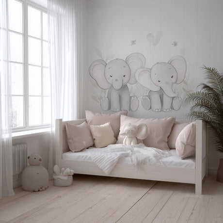 A soft-toned nursery with two hand-drawn baby elephant decals on the wall above a daybed, styled with blush pink pillows, a plush elephant toy, and natural wood accents in a serene, light-filled space.