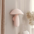 3D printed wall decor shaped like a soft pastel ribbed mushroom with elongated stem, minimalist matte PLA sculpture mounted on a neutral interior wall