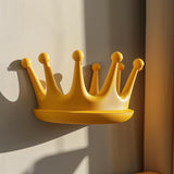 3D printed yellow crown-shaped wall shelf made from matte PLA, used as a small floating ledge in a sunlit kids’ room interior.