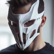 Angular white 3D printed full-face mask with narrow eye openings and futuristic contours.
