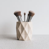 Light beige 3D printed geometric faceted holder, styled with makeup brushes for illustration; brushes are not included.