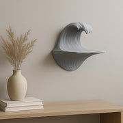 Sculptural grey 3D printed wall shelf shaped like a cresting wave.