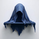 3D printed matte PLA wall shelf shaped like a hooded cloaked wraith with a small straight ledge, mounted on a light-colored wall.