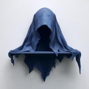 3D printed matte PLA wall shelf shaped like a hooded cloaked wraith with a small straight ledge.