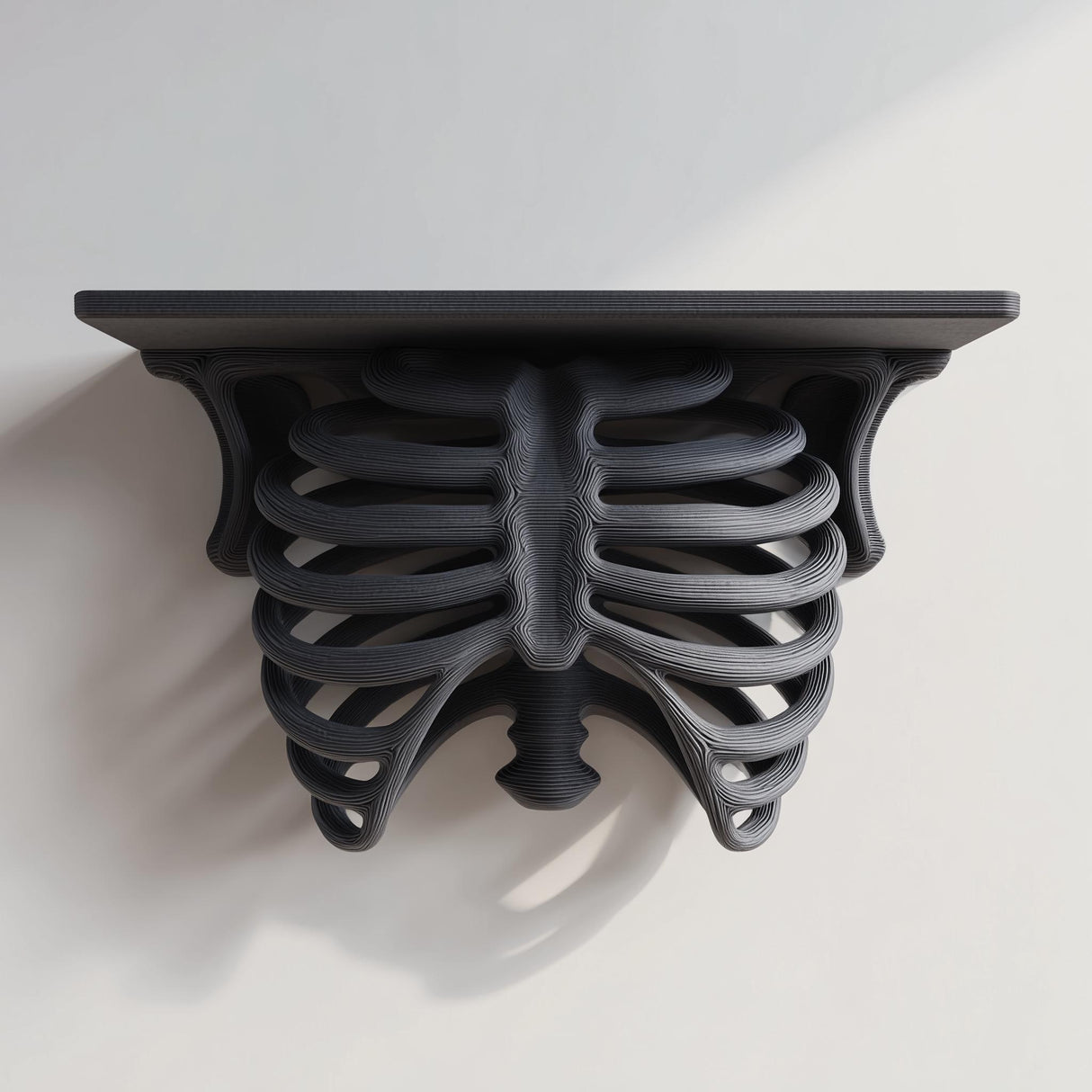 3D printed matte black PLA wall shelf with a realistic ribcage and spine forming the support under a flat rectangular ledge.