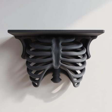 3D printed matte black PLA wall shelf with a realistic ribcage and spine forming the support under a flat rectangular ledge.
