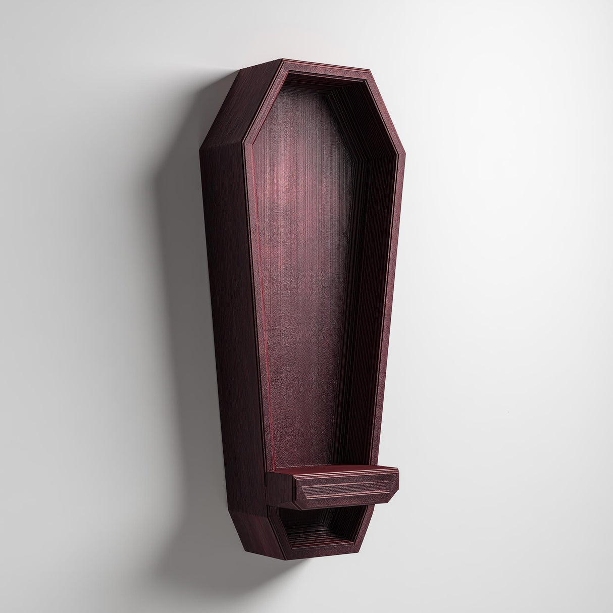 3D printed vertical coffin-shaped wall shelf in dark matte PLA with a small ledge at the bottom, mounted on a light-colored wall.