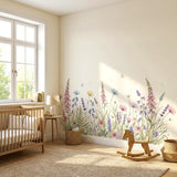 A wide, horizontal watercolor illustration of a wildflower meadow against a white background. The meadow includes tall pink foxgloves, purple lavender, blue bell-shaped flowers, and white daisies. Two small white butterflies and several floating dandelion seeds are scattered among the plants.