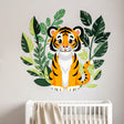 A modern illustration of a cute baby tiger with orange and black stripes sitting on a light grey background. The tiger is surrounded by thick, dark green tropical leaves and foliage that frame its body.