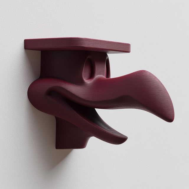 3D printed dark surreal creature wall shelf with elongated beak-like sculptural form and integrated top shelf, mounted on a light interior wall.
