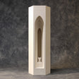 3D printed architectural pet ashes urn shaped as a tall tower with a layered gothic arch recess and a small cat figure inside, studio backdrop.