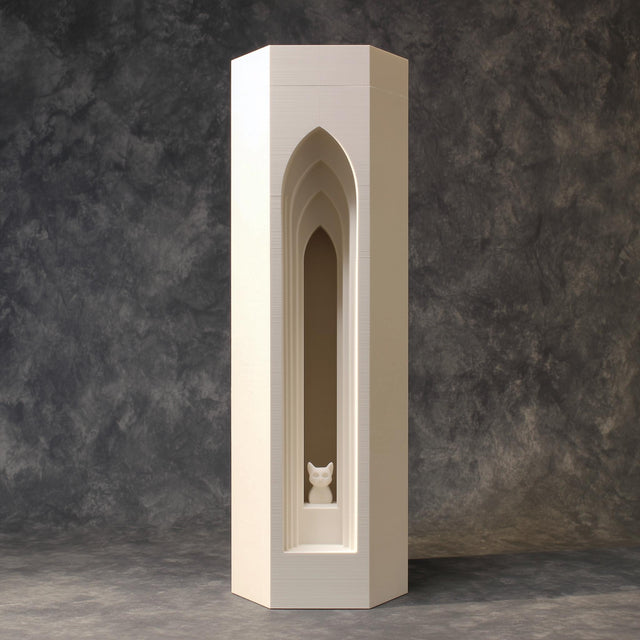 3D printed architectural pet ashes urn shaped as a tall tower with a layered gothic arch recess and a small cat figure inside, studio backdrop.