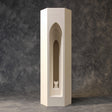 3D printed architectural pet ashes urn shaped as a tall tower with a layered gothic arch recess and a small cat figure inside, studio backdrop.