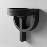 3D printed wall mounted bowl shelf with a round catchall tray and geometric hoop bracket support, visible print texture, mounted on a clean wall.