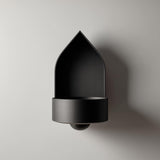 3D printed arched wall mounted shelf with a pointed backplate and a small integrated bowl tray, minimalist sculptural design on a clean wall.