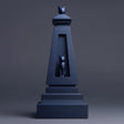 Matte blue 3D printed obelisk-style pet ashes urn with a recessed window showing a small cat figure, minimalist studio grey background, visible print texture.