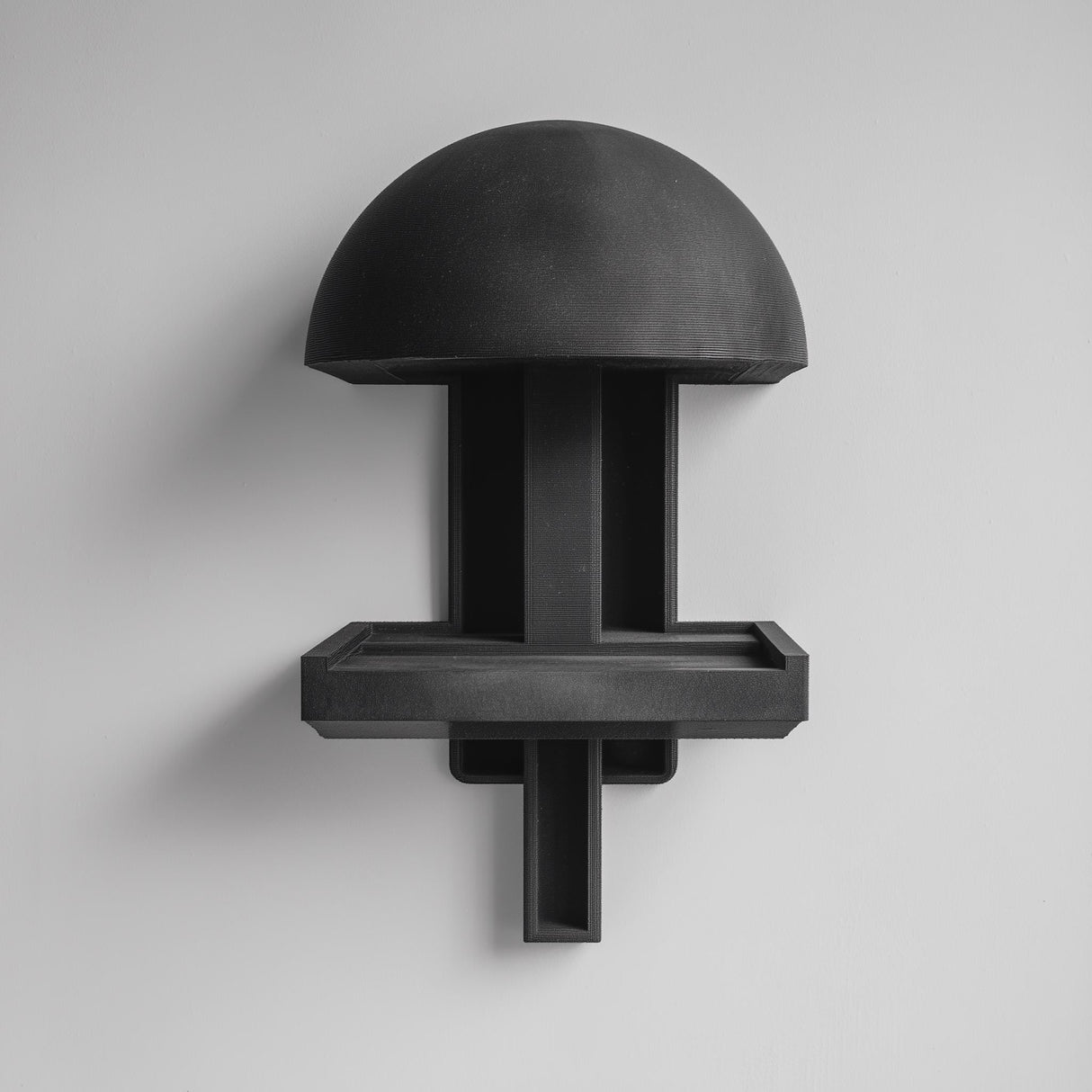 3D printed mushroom-inspired wall mounted shelf with a domed canopy top and a small rectangular floating ledge tray, visible print texture, mounted on a clean wall.