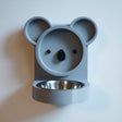 3D printed koala-shaped wall mounted pet bowl holder with a cute face design and a round bowl opening, shown on a clean wall with a bowl placed inside.