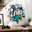 Bold gaming design with large “LEVEL UP!” lettering, a game controller, retro joystick, trophy, pixel star, turquoise crown, blue lightning bolts, and graphic symbols in black, white, turquoise, blue, and yellow.