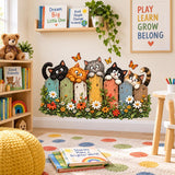 Five playful cats peeking over a colorful garden fence among daisies, green leaves and orange butterflies.